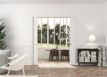 An Eclisse double pocket door system in a room with white wood panelling and architrave but contemporary furniture and lighting